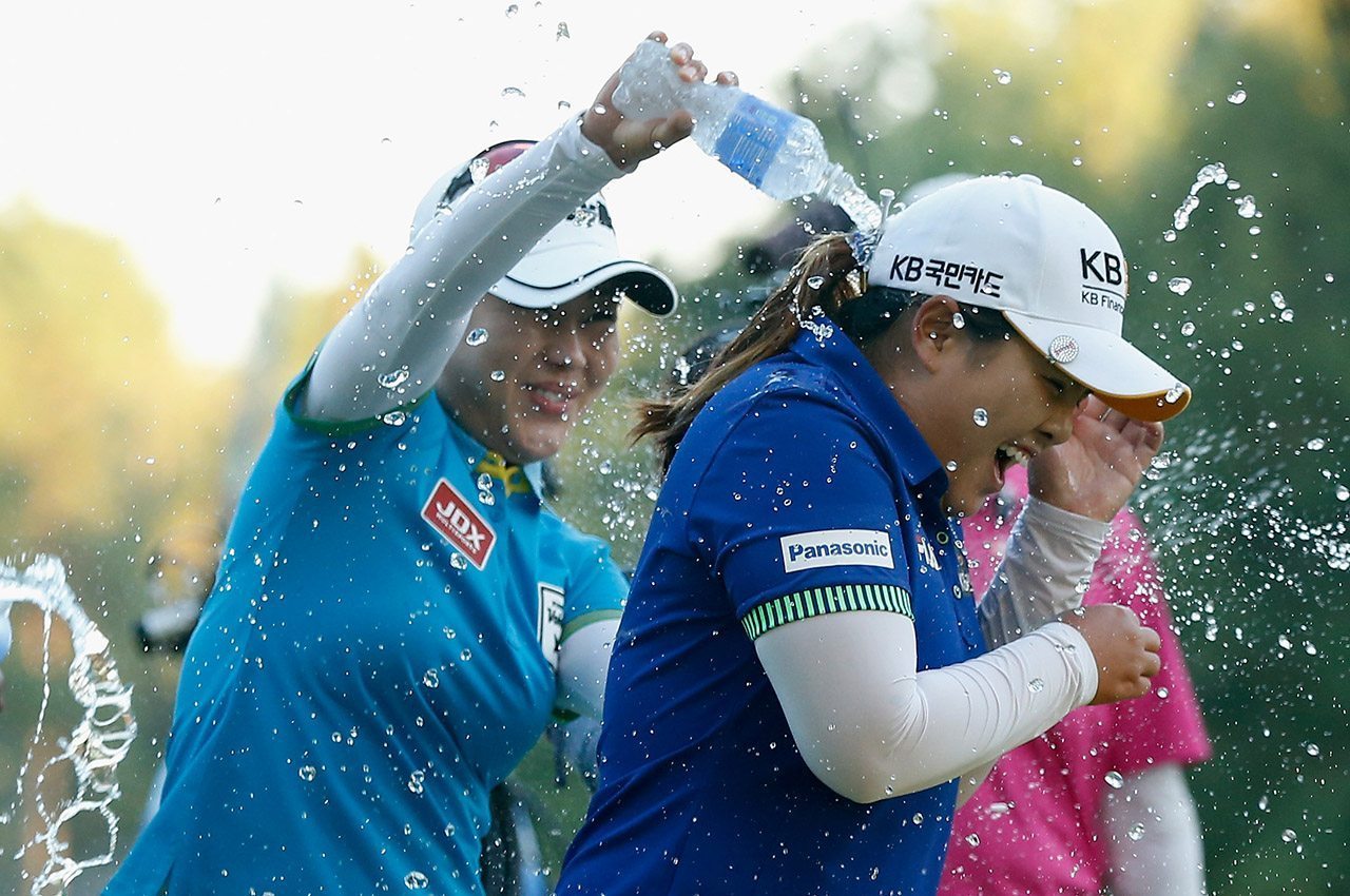 Мина Ли (слева) разбрызгивает воду в парке Инби после того, как Пак победил Бриттани Линциком в первой лунке плей-офф во время чемпионата Wegmans LPGA 2014 года.